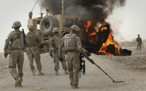 US Army troops scanned the area around a burning armored vehicle that struck an improvised explosive device near Kandahar, Afghanistan, in 2010.